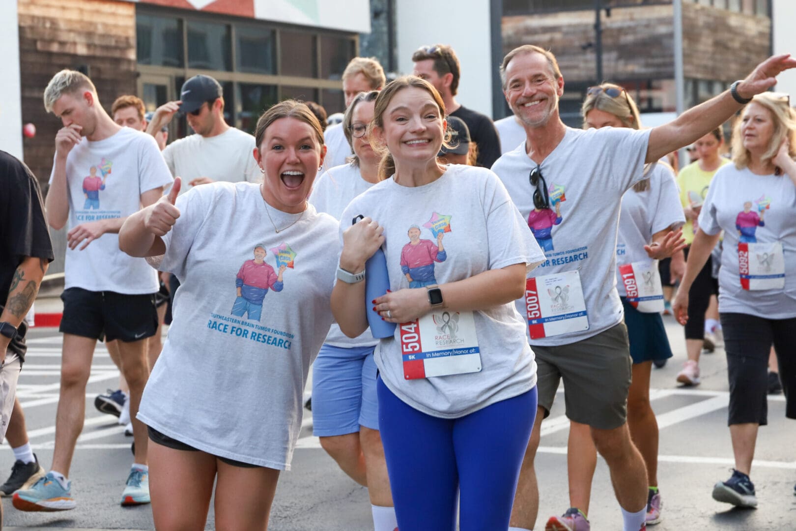 Group of joyful runners celebrating at a community race event.